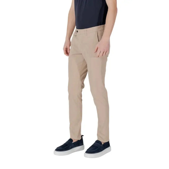 Man wearing khaki slim-fit trousers and blue shoes showcasing Tan Slim-Fit Trousers for Men