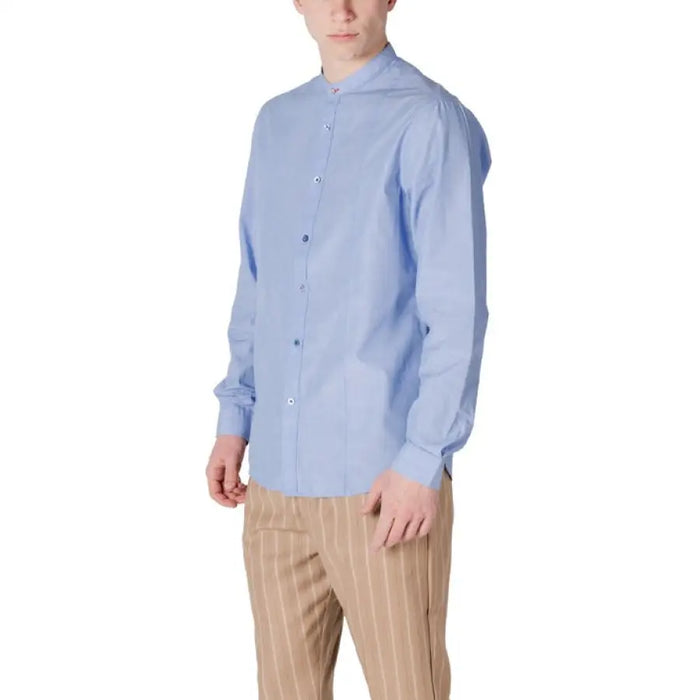 Man in light blue button-down shirt and striped pants showcasing Gianni Lupo shirt