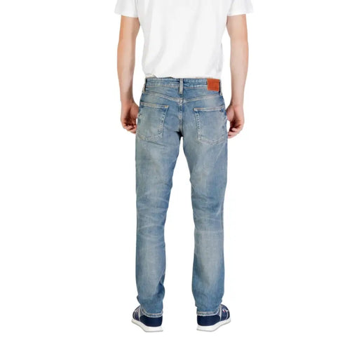 Man wearing light blue jeans and blue sneakers demonstrating style and comfort