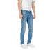 Man wearing light blue denim jeans and white sneakers showcasing casual fashion style