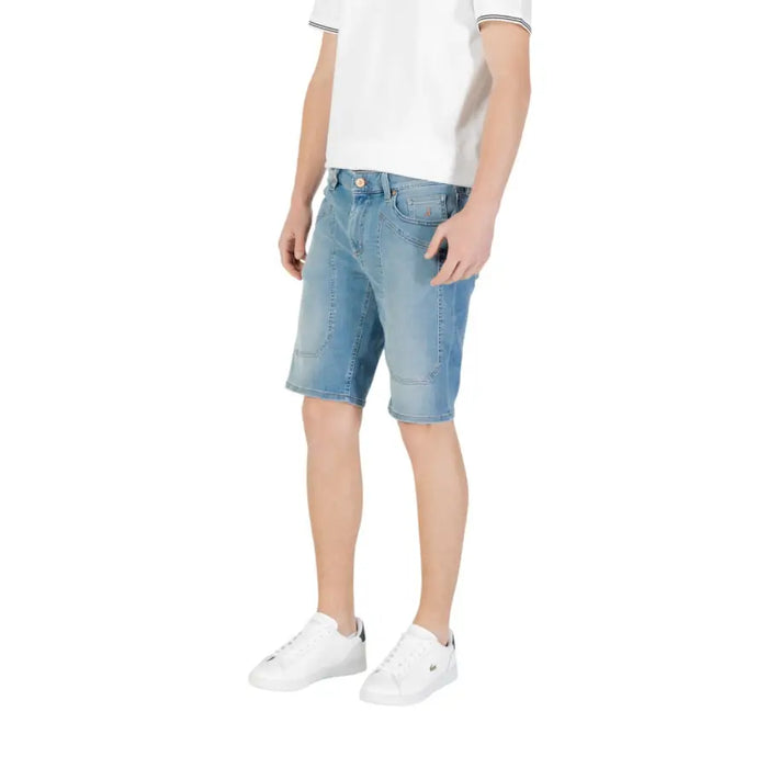 Man wearing light blue denim shorts paired with white sneakers for a casual look