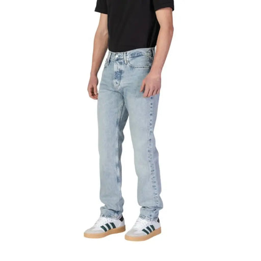 Man wearing Calvin Klein Men’s Blue Organic Cotton Jeans in light wash denim