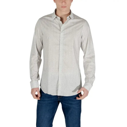 Man in long-sleeved patterned shirt and jeans wearing Armani Exchange t-shirt