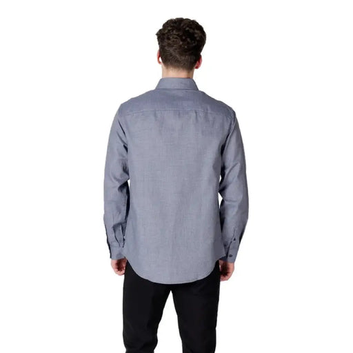 Man in a blue Armani Exchange long sleeve shirt showcasing stylish apparel