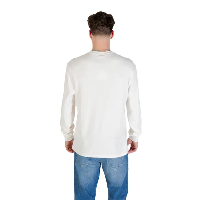 Man in long-sleeved white shirt and blue jeans for the product Man in Long Sleeve Shirt and Blue Jeans
