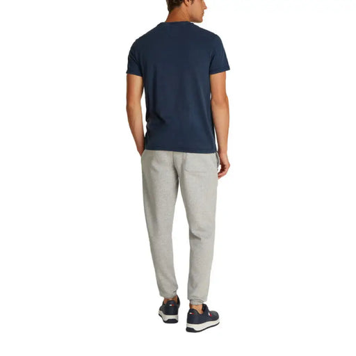 Man wearing a navy T-shirt and gray pants showcasing casual men’s fashion