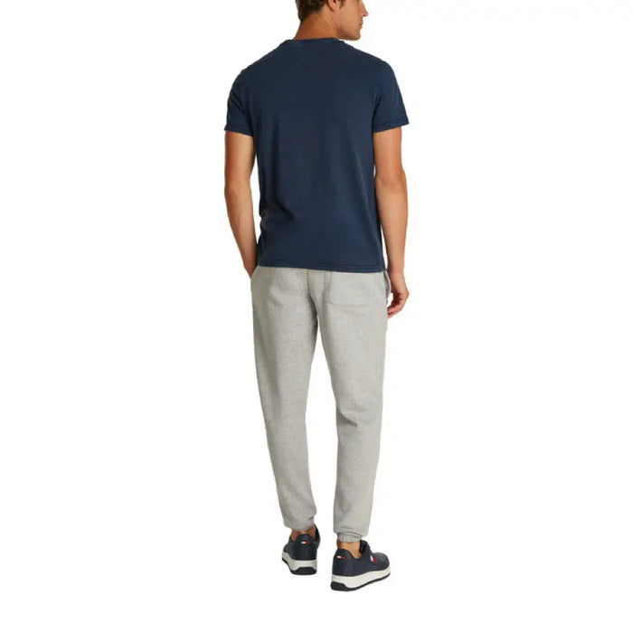 Man wearing a navy T-shirt and gray pants showcasing casual men’s fashion