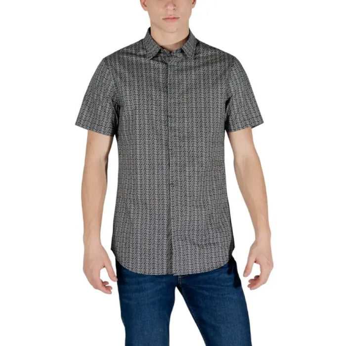 Man in beige geometric shirt by Armani Exchange with short sleeves and unique patterns