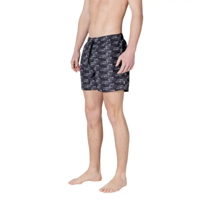 Man in patterned swim trunks showcasing Ea7 Men Swimwear Black Print Spring Summer