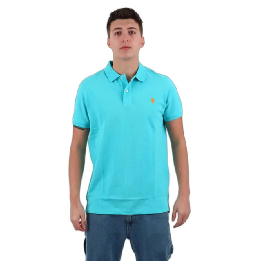 Man in turquoise U.S. Polo Assn. shirt and jeans, showcasing men polo apparel accessories.