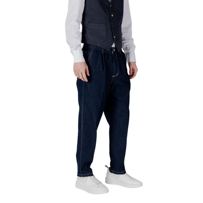 Man wearing dark blue vest and loose pants with white stitching for a stylish look