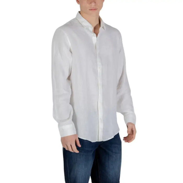 Man in white button-down shirt and blue jeans showcasing Armani Exchange Men’s White Linen Shirt