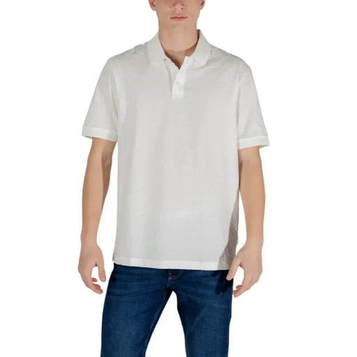 Man in white polo shirt and blue jeans featuring Armani Exchange Men’s White Cotton Polo