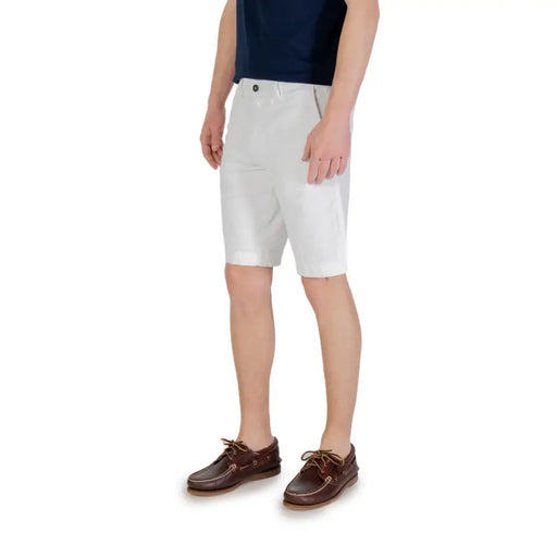 Man wearing white chino shorts and brown boat shoes in fashion ensemble image
