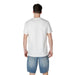 Man in white t-shirt and denim shorts wearing Armani Exchange Men White Short Round Neck Cotton T-Shirt