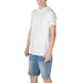 Man in white cotton t-shirt and blue denim shorts by Armani Exchange
