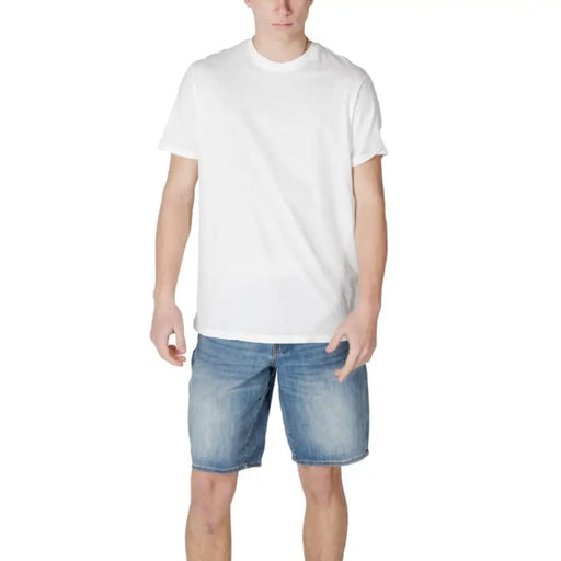 Man in white round neck cotton t-shirt and denim shorts by Armani Exchange
