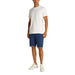 Man wearing a white T-shirt and blue denim shorts with cuffed hems