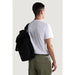 Man in white Napapijri cotton t-shirt and green cargo pants with black backpack