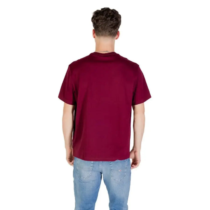 Maroon Calvin Klein T-shirt paired with classic blue jeans for a stylish look