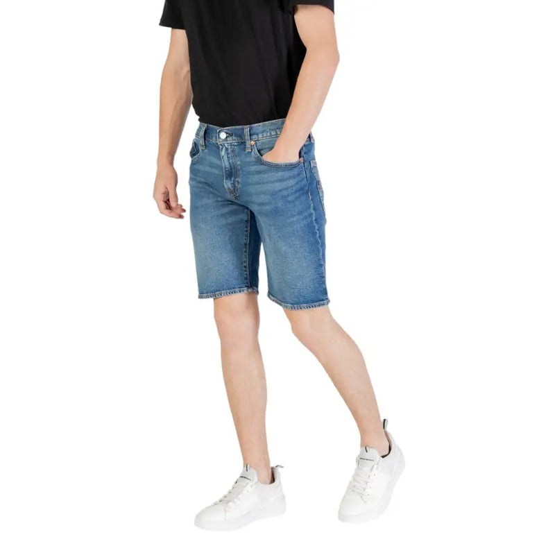 Short en jean bleu pour homme, coupe classique cinq poches et ourlet effiloché, confectionné en denim résistant.