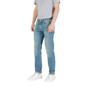 Men’s light blue denim jeans with a slim fit, subtle fading, classic stitching, and branded patch on the back pocket view