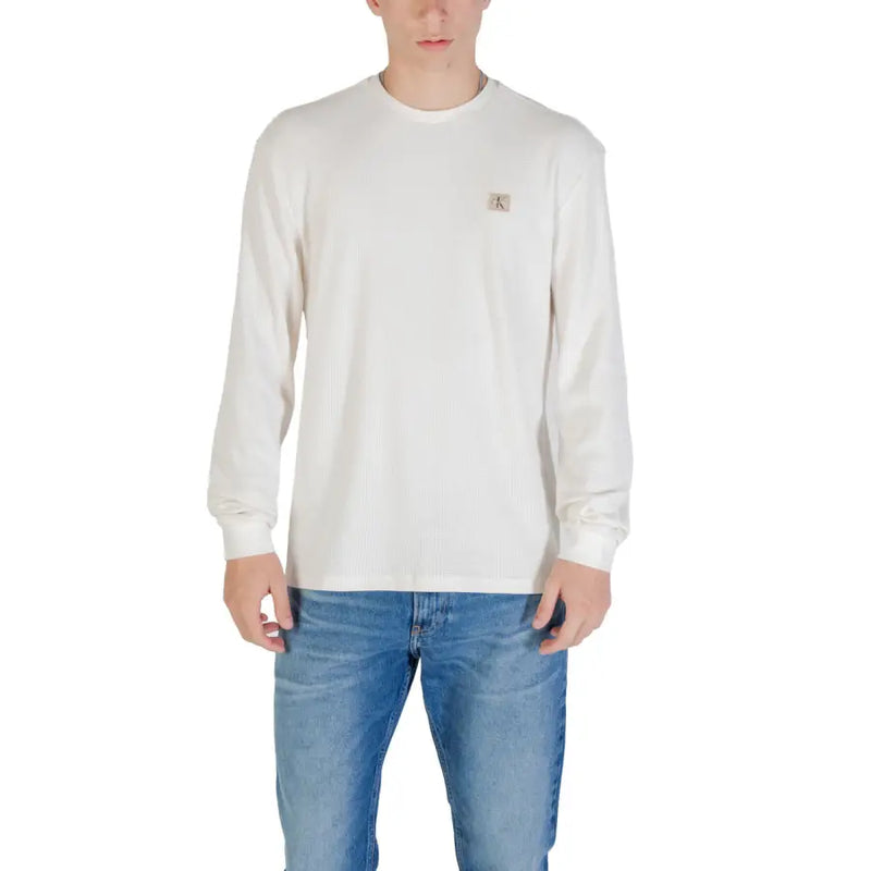 Men’s off-white long sleeve crew neck sweater with small beige logo patch on left chest in soft cotton material