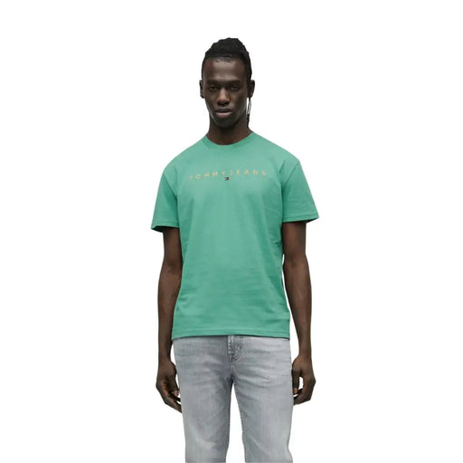 Mens white tommy jeans short sleeve t shirt featuring a teal color with a subtle gold logo across the chest