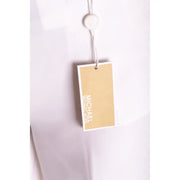 Une étiquette beige de la marque Michael Kors avec des lettres blanches est attachée à un pantalon blanc stretch pour femme à fermeture éclair et boutons.