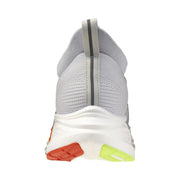 Baskets sportives grises pour homme Mizuno, avec un mélange de tissu en maille grise, une semelle intermédiaire blanche et des accents vert fluo orange sur la semelle extérieure.