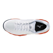 Baskets Mizuno pour homme en tissu blanc avec des détails orange et une semelle extérieure en caoutchouc noir, conçues pour la performance au volleyball.