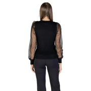 Woman wearing Morgan De Toi black long sleeve round neck blouse with sheer puffed sleeves