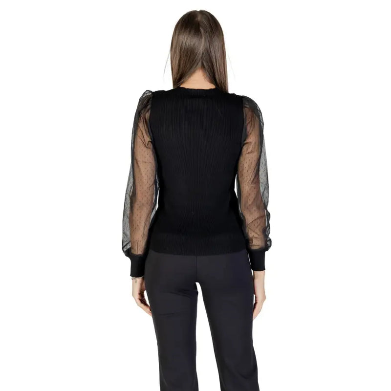 Woman wearing Morgan De Toi black long sleeve round neck blouse with sheer puffed sleeves
