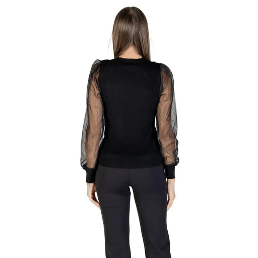 Woman wearing Morgan De Toi black long sleeve round neck blouse with sheer puffed sleeves