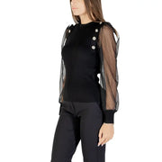 Black long-sleeved blouse with sheer dotted mesh sleeves and decorative buttons