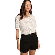 White lace short-sleeved blouse with intricate geometric patterns and gold-toned buttons paired with Morgan De Toi black polyester blend women’s shorts