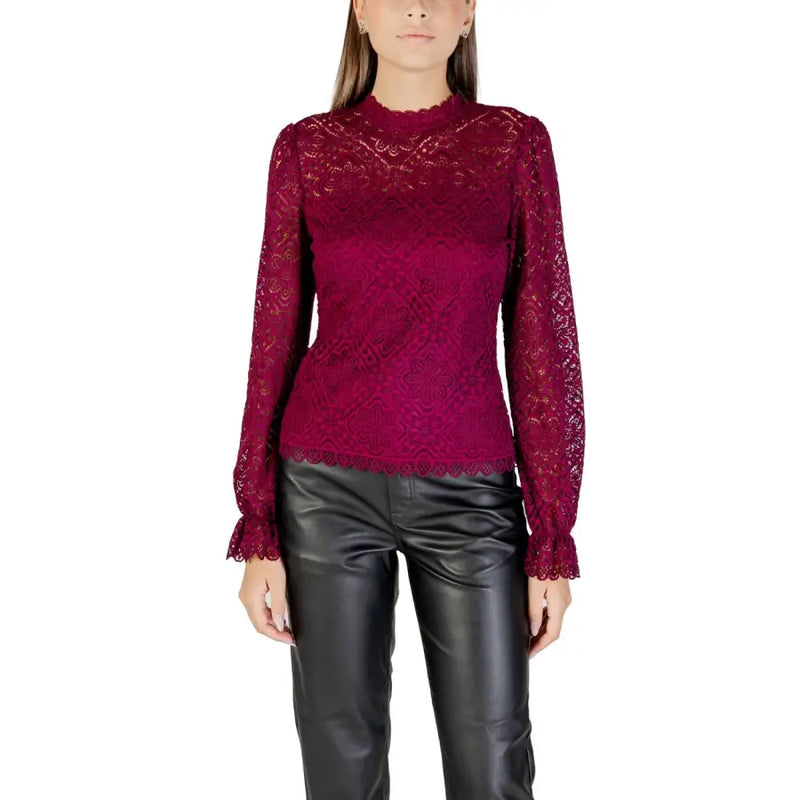 Woman wearing a dark red lace top and black leather pants showcasing Morgan De Toi blouse