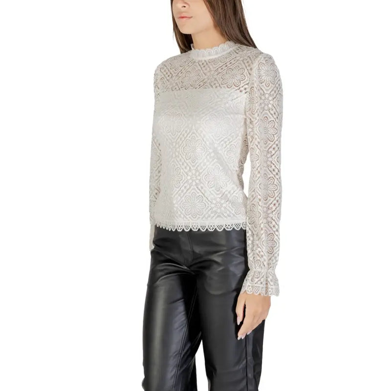 Women’s white lace long-sleeve blouse with mock neck paired with black faux leather pants