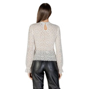 Women’s beige lace long-sleeve top with keyhole back paired with black leather pants