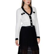 White and black fuzzy knit cardigan with pearl buttons paired with a black pleated midi skirt