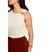 Broche soleil dorée épinglée à l'épaule d'une Morgan De Toi pull beige sans manches pour femme top couleur crème