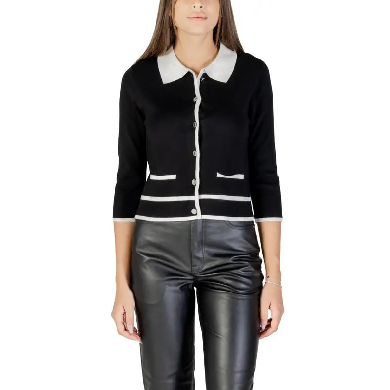 Woman wearing Morgan De Toi black cardigan with white collar and leather pants