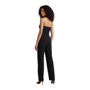 Combinaison moulante noire sans bretelles avec pantalon tailleur, portée avec des talons hauts de chez Morgan De Toi collection de coton