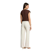 Une femme porte un Morgan De Toi pull sans manches marron pour femme top associé à un pantalon large crème