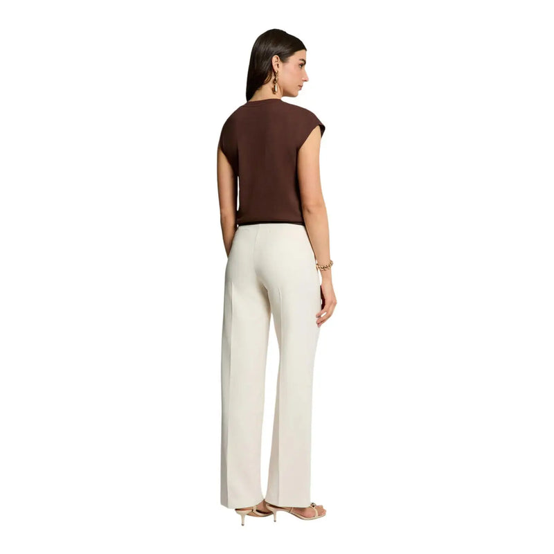 Une femme porte un Morgan De Toi pull sans manches marron pour femme top associé à un pantalon large crème