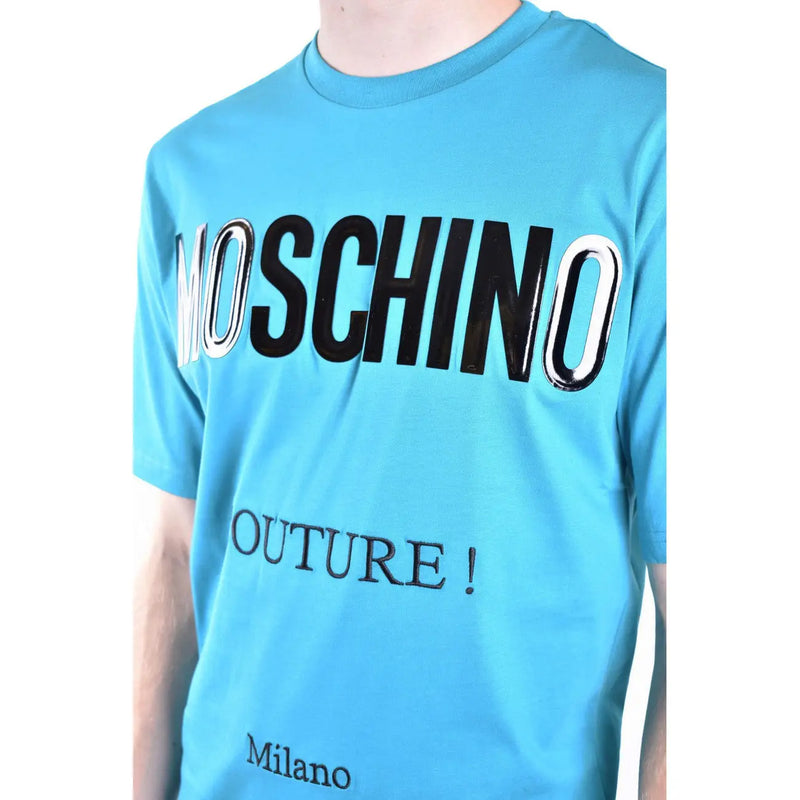 Light blue Moschino men t-shirt featuring bold black and silver glossy Moschino lettering with smaller couture text below