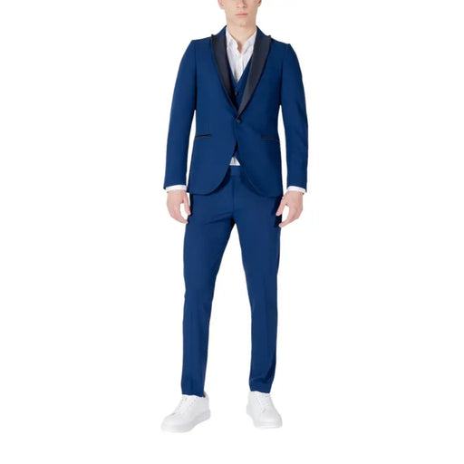 Men’s navy blue three-piece suit with black shawl lapel, white shirt, and white sneakers