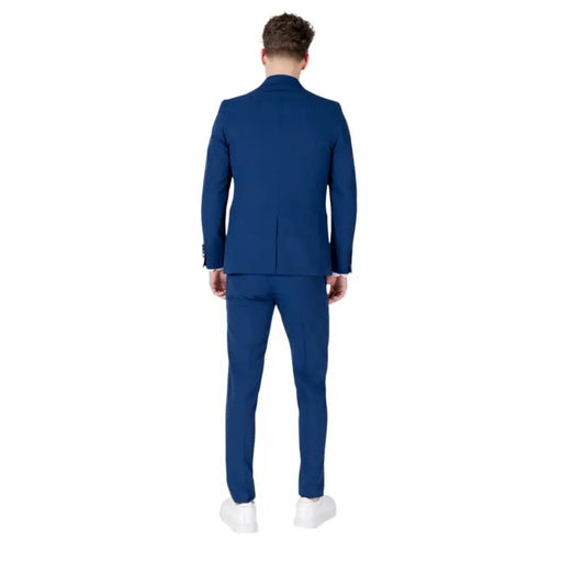Men’s slim-fit blue suit with lapel collar and white sneakers displayed in Mulish collection