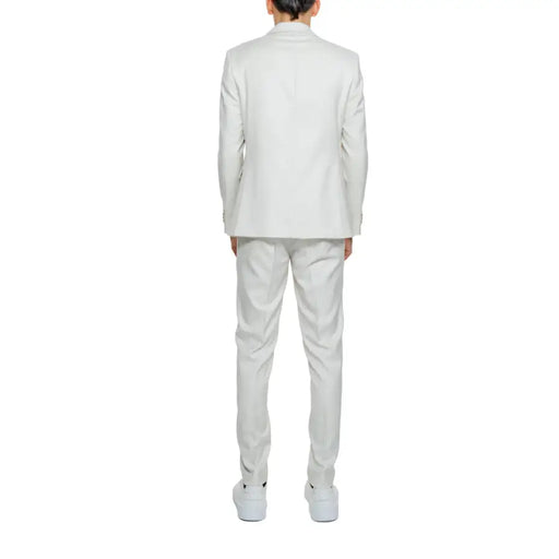 Un tailleur blanc impeccable, composé d'une veste structurée et d'un pantalon assorti, confectionné dans un tissu lisse en mélange polyester-viscose.