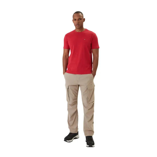 Pantalon cargo beige à multiples poches latérales et finitions discrètes napapijri logo sur la cuisse gauche associé à un t-shirt en coton rouge